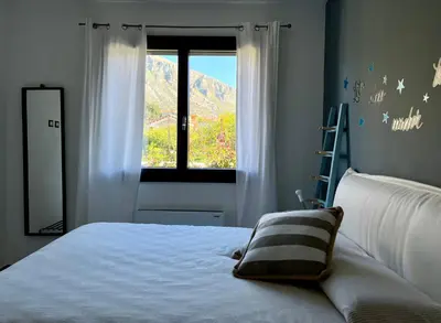 a bedroom with a blue bed with two pillows at Rosalia Homestay - Ponente Apartment in Cinisi
