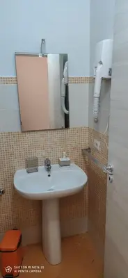 a bathroom with a white sink and a mirror at B&B AMISTANZA in Palermo