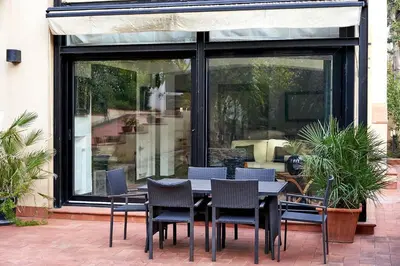 a black table and chairs in front of a window at LuminHouse Mondello Valdesi in Palermo