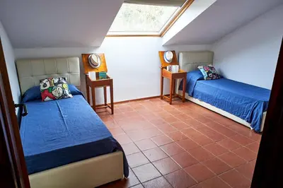 a attic bedroom with two beds and a window at LuminHouse Mondello Valdesi in Palermo