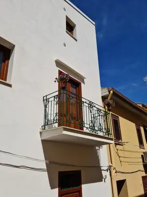 a white building with a balcony with flowers on it at Voltamare in Castellammare del Golfo