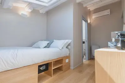 a small bedroom with a bed and a table at Archè Design Rooms and Suites in Palermo