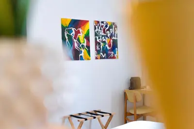 a room with two chairs and a painting on the wall at Archè Design Rooms and Suites in Palermo