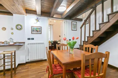 a kitchen and dining room with a wooden table and chairs at Vittorio Emanuele & Via Roma Colorful Apartment in Palermo