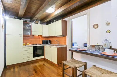 a kitchen with white cabinets and a counter top at Vittorio Emanuele & Via Roma Colorful Apartment in Palermo