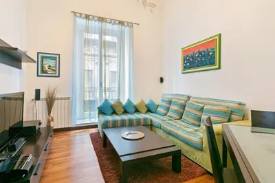 a living room with a couch and a table at Vittorio Emanuele & Via Roma Colorful Apartment in Palermo