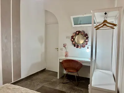 a bedroom with a desk with a mirror and a chair at Casa Raffadali, in centro storico a Palermo in Palermo