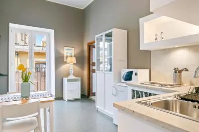 a kitchen with white cabinets and a sink at GuestHost - Stylish Flat Maqueda in Palermo