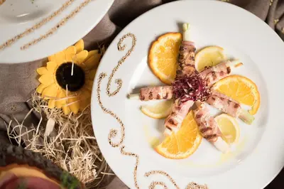 a plate of food with orange slices and bacon at Valle Himara in Piana degli Albanesi