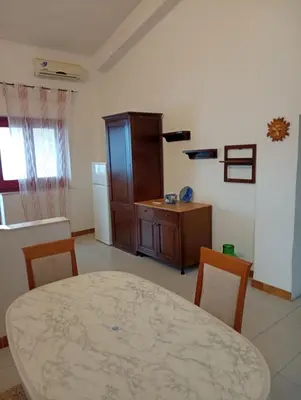 a living room with a table and a kitchen at la finestra sul mare piano 2 in Trappeto