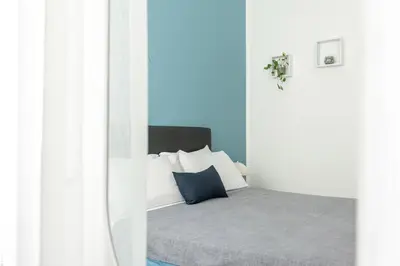 a bedroom with a bed with blue and white pillows at Maqueda House in Palermo