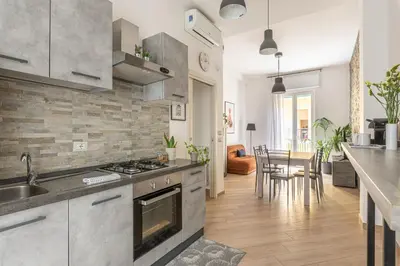 a kitchen with stainless steel appliances and a dining room at Maqueda House in Palermo