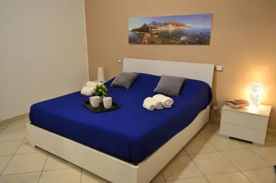 a bedroom with a blue bed with towels on it at Appartamento del Golfo in Castellammare del Golfo