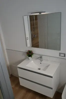 a bathroom with a white sink and a mirror at Appartamento del Golfo in Castellammare del Golfo