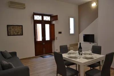 a living room with a table and chairs and a tv at Appartamento del Golfo in Castellammare del Golfo