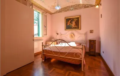 a bedroom with a bed and a painting on the wall at Cozy Apartment In Castellammare Dg in Castellammare del Golfo