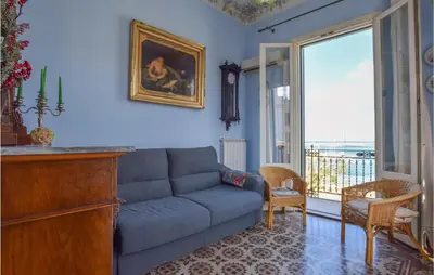 a living room with a blue couch and a window at Cozy Apartment In Castellammare Dg in Castellammare del Golfo