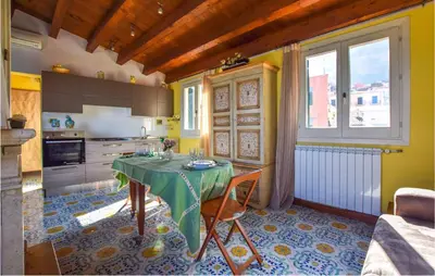 a kitchen with a table with a green table cloth at Cozy Apartment In Castellammare Dg in Castellammare del Golfo