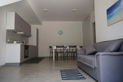 a living room with a couch and a kitchen at Appartamenti AcquaChiara in San Vito lo Capo