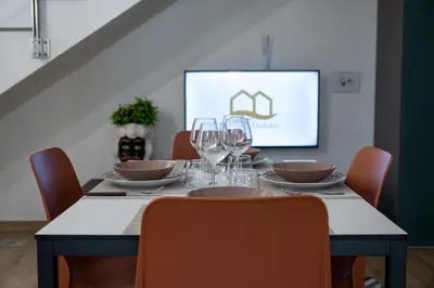 a dining room table with wine glasses and a screen at Residence Salinelle Beach Villa Salina 5 in Lascari