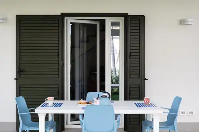 a table and chairs in front of a house at Residence Salinelle Beach Villa Salina 5 in Lascari