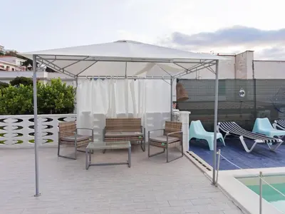 a white canopy on a patio with chairs and a pool at Apartment in Alcamo near the Beach in Alcamo Marina