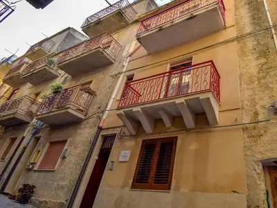 an apartment building with red balconies on a street at Apartment SinAgo by Interhome in Lascari