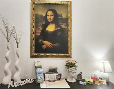 a painting of a woman is hanging on a wall at Guastella House in Palermo