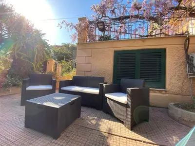 a group of chairs and tables on a patio at mondello beach luxury apartments in Palermo
