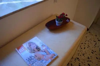 a book and a vase on a table with a plant at mondello beach luxury apartments in Palermo
