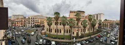 a large building with palm trees in a city at home.70 Carini in Palermo