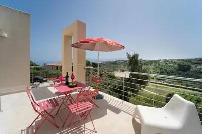 a patio with a table and chairs and an umbrella at B&B Kòre in Castellammare del Golfo