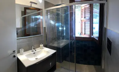 a bathroom with a sink and a glass shower at Villa Smeralda in San Vito lo Capo