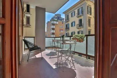 a balcony with a table and chairs and a window at Libertà Central Suites in Palermo
