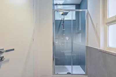 a shower with a glass door in a bathroom at Libertà Central Suites in Palermo