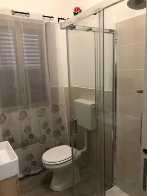 a bathroom with a toilet and a glass shower at Dal Barce Rooms in Palermo