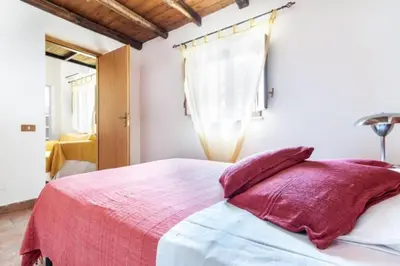 a bedroom with a bed with a red blanket and pillows at Historical Penthause Ballarò with view in Palermo