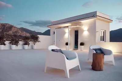 two chairs and a stump in front of a house at Sea view life in Carini