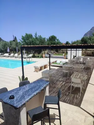 a patio with a table and chairs next to a pool at Inkantu B&B in Terrasini
