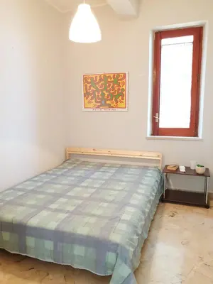a bedroom with a bed and a window at Villa Flore - Penthouse - apartment in villa in Casteldaccia