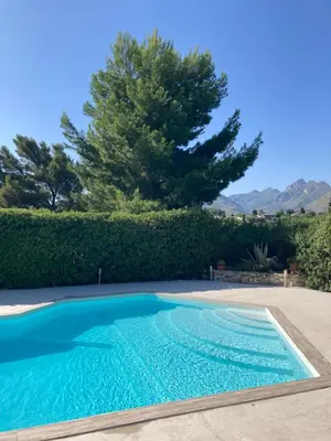 a swimming pool in a yard with a tree at Villa Flore - Penthouse - apartment in villa in Casteldaccia