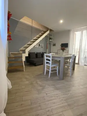 a living room with a table and chairs and a staircase at Il mio posto ai Quattro Canti - Centro storico Palermo in Palermo