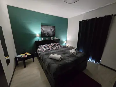 a bedroom with a bed and a green wall at Virginia House 2 in Palermo