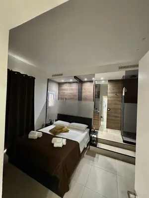a bedroom with a large bed and a bathroom at Suites Central Station in Palermo