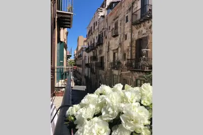 a bunch of white flowers sitting on a balcony at Piazza Marina Open Space in Palermo