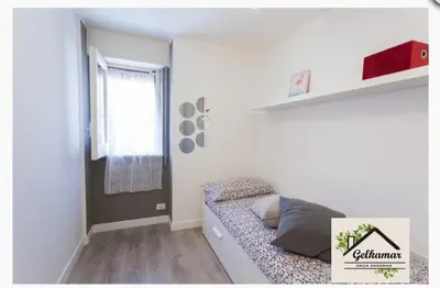 a small white room with a bed and a window at Gelkamar Apartment in Santa Flavia