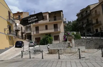 a building with a sign that reads no rooms for guests at la porta del corso in Castronuovo di Sicilia