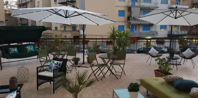 an outdoor patio with tables and chairs and umbrellas at Civico 20 in Palermo