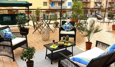 an outdoor patio with chairs and tables and plants at Civico 20 in Palermo