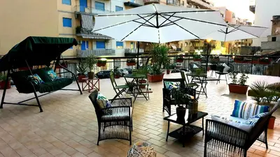 an outdoor patio with chairs and tables and umbrellas at Civico 20 in Palermo